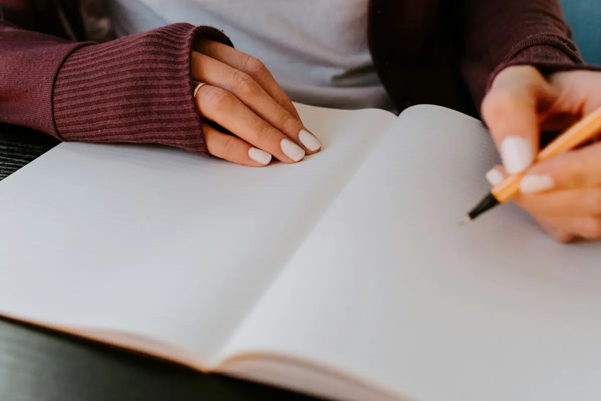 Hands resting on a blank notebook, ready to write